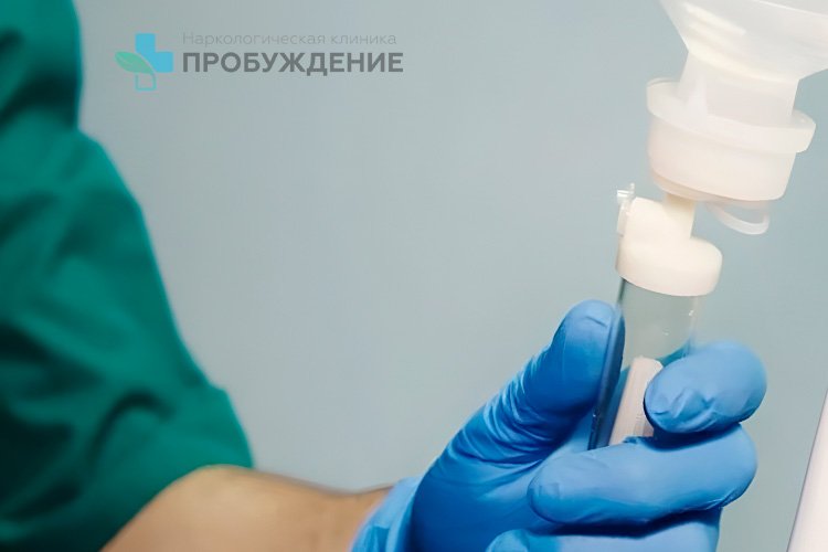 доктор в синих перчатках и капельницей в руках